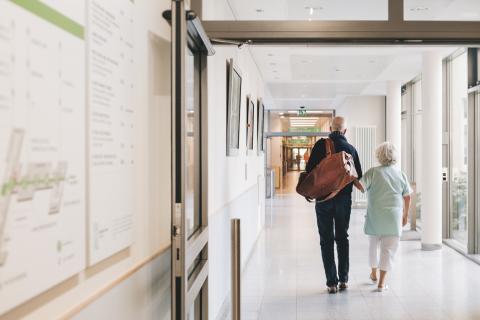 Ehrenamtliche Damen und Herren unterstützen die Patienten am St. Joseph-Stift – auf dem Weg ins Zimmer.