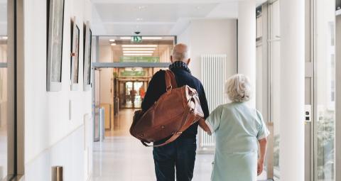 Ehrenamtliche Mitarbeiterin führt einen Patienten durch das Krankenhaus St. Joseph-Stift.