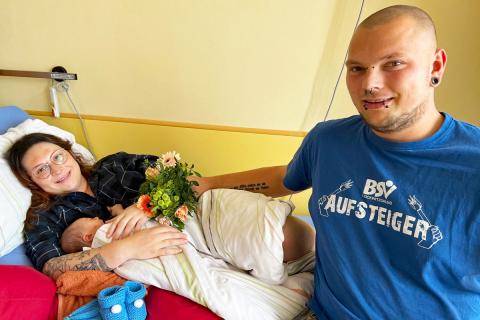 1000. Geburt 2023 im St. Joseph-Stift: Foto von Familie Böhme mit dem neugeborenen Sohn Jonas am Krankenhausbett.