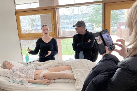 Auszubildende Sophia demonstriert einen Teil der generalistischen Pflegeausbildung an einer Puppe.