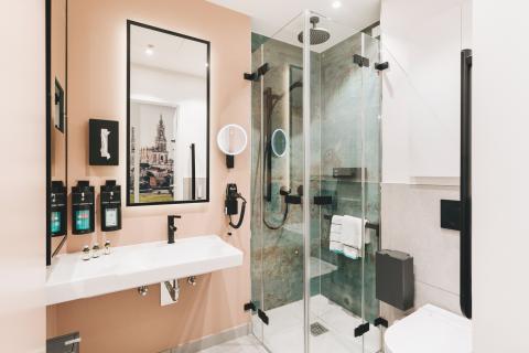 Wahlleistungszimmer im Krankenhaus St. Joseph-Stift Dresden: Das Badezimmer mit Dusche, Waschbecken und WC im gehobenen Hotel-Stil.
