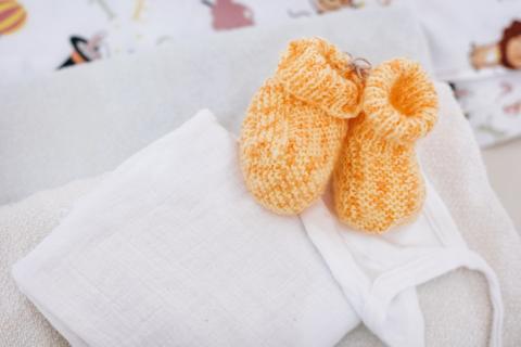 geburtshilfe, Detail gestrickte Babyschuhe in gelb