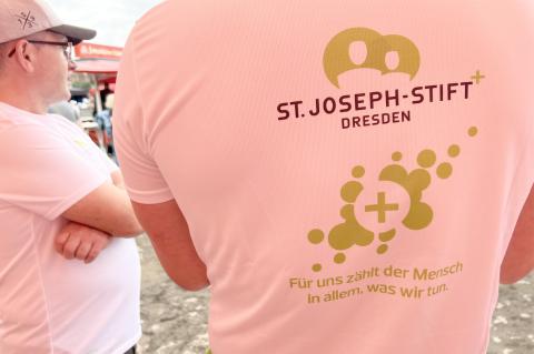 St. Joseph-Stift sportlich: Sportshirt aus dem Krankenhaus St. Joseph-Stift für Team- und Sportevents; Rückansicht mit Logo und Spruch: "Für uns zählt der Mensch, in allem, was wir tun."