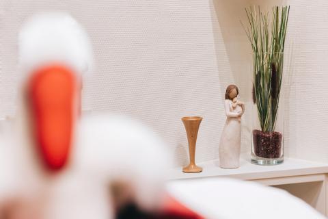 Geburtshilfe im St. Joseph-Stift: Im Hintergrund Hebammen-Hörrohr und kleine Figur "Mutter mit Kind", im Vordergrund der Storch.