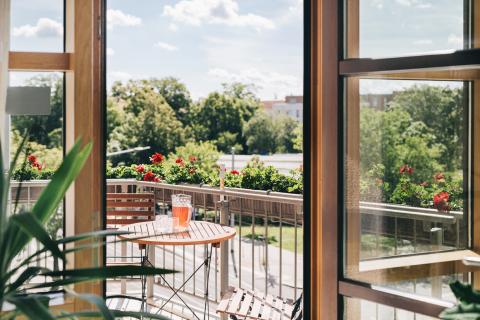 Detail: Blick aus dem Wintergarten der Wochenstation auf den begrünten Balkon mit Sitzmöglichkeiten.