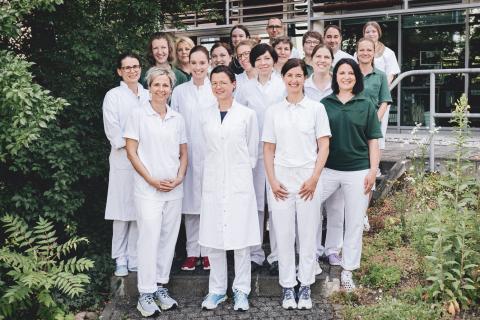 Gruppenbild: Teamfoto Schmerztherapie – Fachkräfte aus Medizin, Pflege und Therapie im Patientengarten des St. Joseph-Stift.