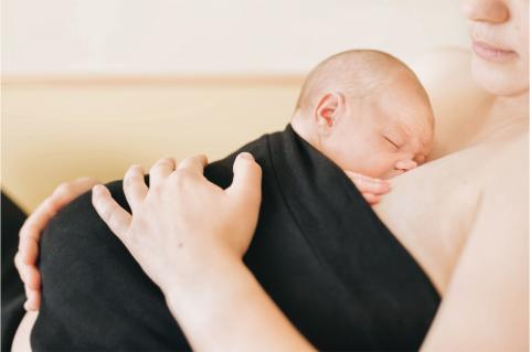 Bonding: Neugeborenes und Mutter in intensivem Körperkontakt.