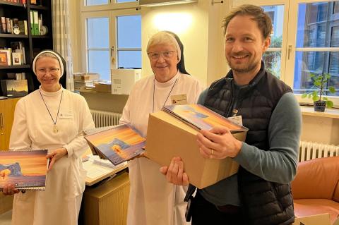 Seelsorge-Team (zwei Ordensschwestern links und in der Mitte sowie Seelsorger Manuel Henning rechts im Bild) verteilen den Kalender "Der andere Advent" im Krankenhaus.