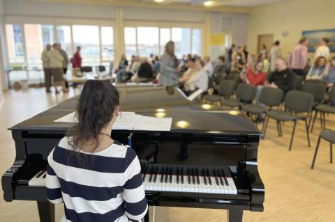 Patiententag Brustzentrum 2024: Atmosphäre. Im Vordergrund Musikerin am Klavier, im Hintergrund füllt sich der Veranstaltungssaal.