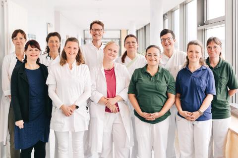 Gruppenfoto: Multiprofessionelles Team in der Geriatrie – 11 Mitarbeitende, darunter Mediziner, Pflege, Verwaltung, Therapie, Sozialdienst, Psychologie.