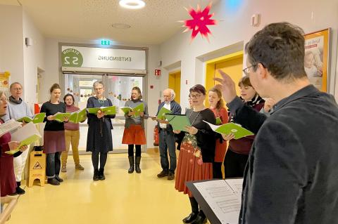 Weihnachtsgruss 2024 aus dem St. Joseph-Stift. Aufnahme des Mitarbeiterchors beim Weihnachtsliedersingen auf einer unserer Stationen.