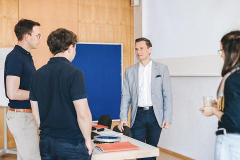 Kursleiter im Gespräch mit Kursteilnehmenden in der Akademie für Palliativmedizin und Hospizarbeit.