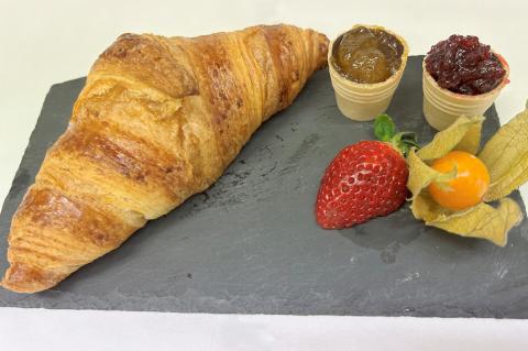 Croissant pur, serviert mit gelber und roter Konfitüre, dazu eine Deko aus Physalis und Erdbeere – Teil des Frühstücksangebots in der Cafeteria am St. Joseph-Stift.