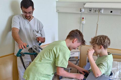 Austesten zum Boy's Day: Zwei Schüler am Patientenbett, daneben gibt ein Pfleger Anweisungen.
