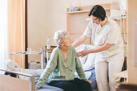 Pflegerische Zuwendung auf der Palliativstation im St. Joseph-Stift: Eine Schwester hilft einer Patientin beim Aufstehen aus dem Bett.