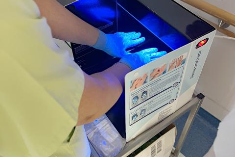 Test der desinfizierten Hände unter der UV-Lampe.