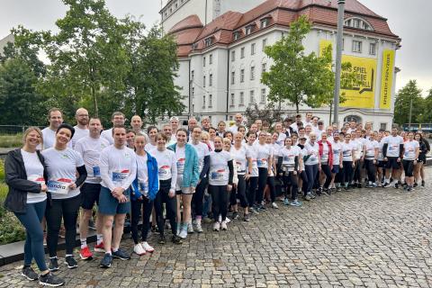 Teamfoto Läuferinnen und Läufer aus dem St. Joseph-Stift kurz vor dem Start in der ersten Startwelle. Im Hintergrund: Das Schauspielhaus des Dresdner Staatsschauspiels auf dem Postplatz.