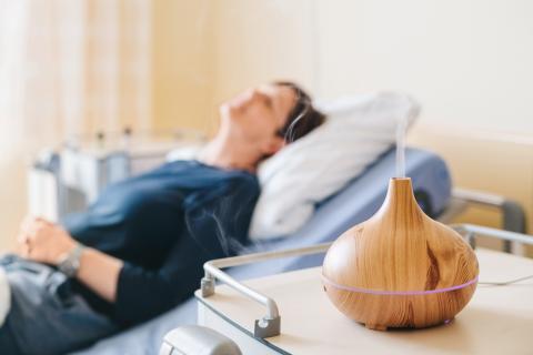 Schmerztherapie im St. Joseph-Stift – Patienten auf Bett im Hintergrund, im Vordergrund Aromalampe zur unterstützenden Schmerzbehandlung.