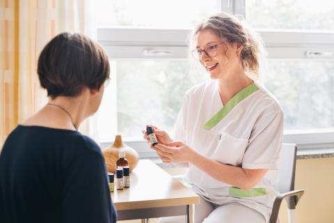 Schmerztherapie im St. Joseph-Stift – Schwester bei der Beratung einer Patientin zum Einsatz der Aromatherapie als unterstützende Schmerzbehandlung.
