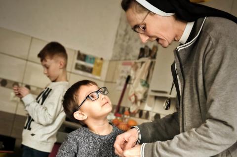 Weihnachten verschenken: Kleiner Junge und Dolores, die ihm etwas gibt.