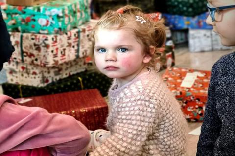 Weihnachten verschenken: Kleines Mädchen mit Geschenken.