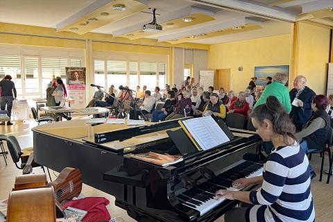 Patiententag Brustzentrum 2025, Veranstaltungssaal voller Menschen, im Vordergrund Musikerin Marion Fiedler am Flügel.