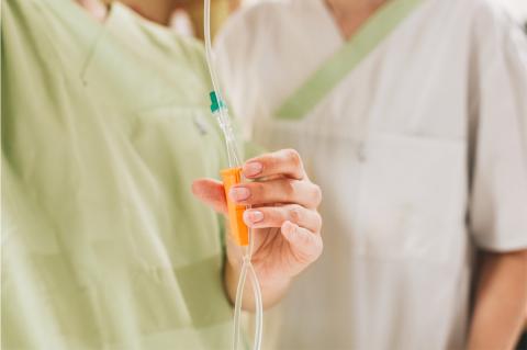 Pflegeausbildung am St. Joseph-Stift: Herstellung einer Infusion, Aufhängung und Einstellung der Tropfgeschwindigkeit. Detailaufnahme am Infusionsständer, Hände im Fokus.