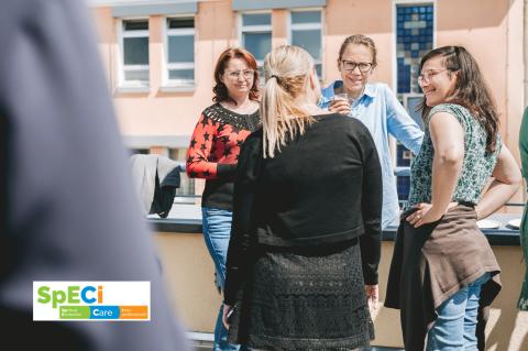 SpECi©-Kurs Akademie für Palliativmedizin und Hospizarbeit, Pausengespräch mehrerer Teilnehmerinnen auf der Terrasse am Seminarraum, mit SpECi©-Logo.