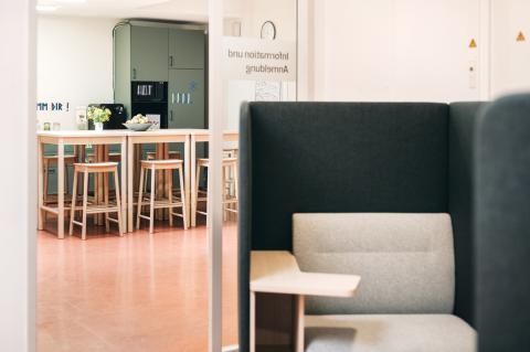 Akademie für Palliativmedizin und Hospizarbeit, Blick in die Räume, hier: Detail offener Sitz-, Ess- und Arbeitsbereich in der Gemeinschaftsküche, seitlich im Anschnitt Sitzbereich als separierte Lernecke.