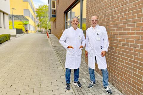 Erweiterung der Klinik für Plastische Chirurgie am St. Joseph-Stift; im Hintergrund Zufahrt zum St. Joseph-Stift, im Vordergrund die Ärzte der Plastischen Chirurgie, links Prof. Dragu, rechts Dr. Sieber – neuer Standortleiter vor Ort.